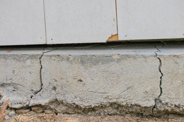 Specialist inspecting slab cracks and elevation changes with professional measuring tools on site